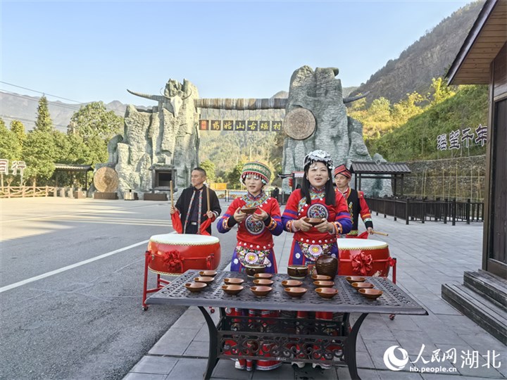 通城县内冲瑶族村，瑶族阿哥阿妹们在门楼前为游客送上拦门酒。人民网 周雯摄